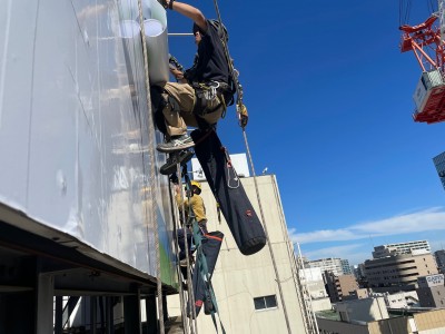 2023年10月23日松戸駅前にて塔屋看板原状回復白シート上貼り施工